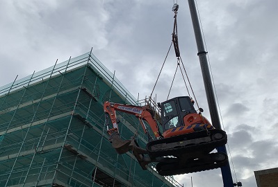 Digger being lifted by a crane